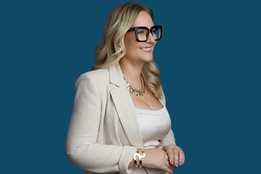 Broker, Mafalda Emilio num fundo azul, de perfil com óculos castanhos 